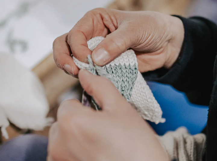 Hands knitting an Aran wool sample